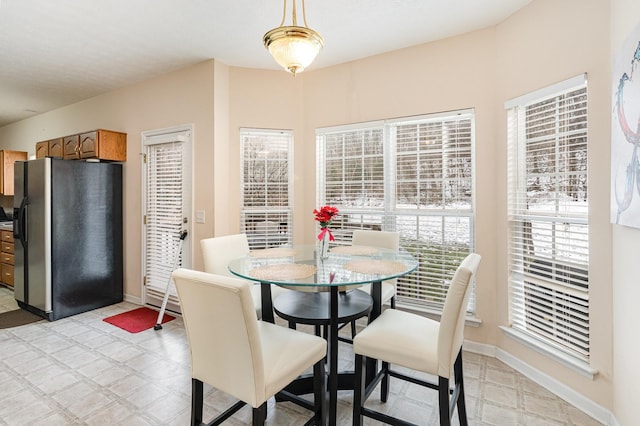 dining area featuring light floors and baseboards