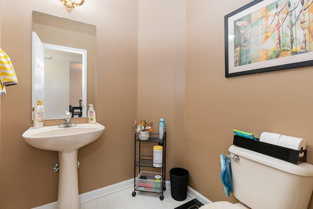 bathroom featuring toilet and baseboards