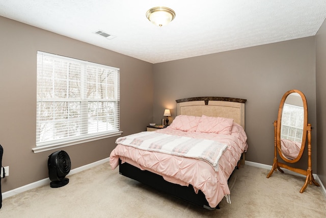 bedroom with visible vents, light colored carpet, and baseboards