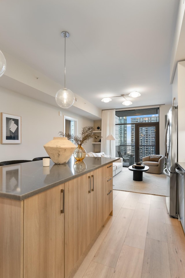 kitchen with modern cabinets, light wood-style flooring, light brown cabinets, and freestanding refrigerator