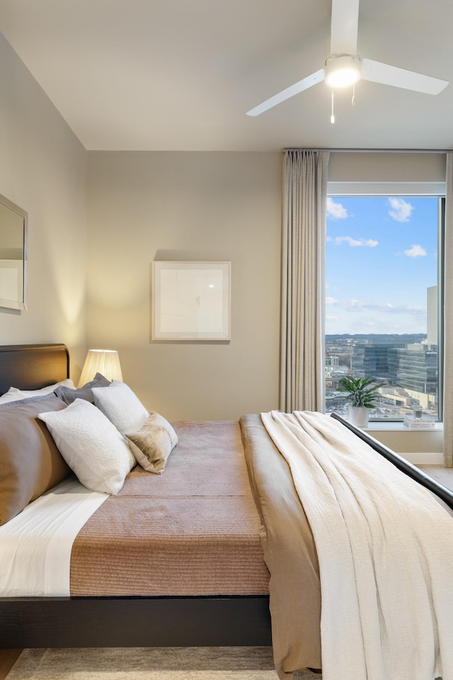 bedroom with a city view and a ceiling fan