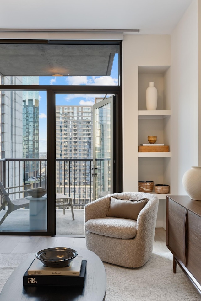 living area with a wall of windows, built in shelves, and a city view