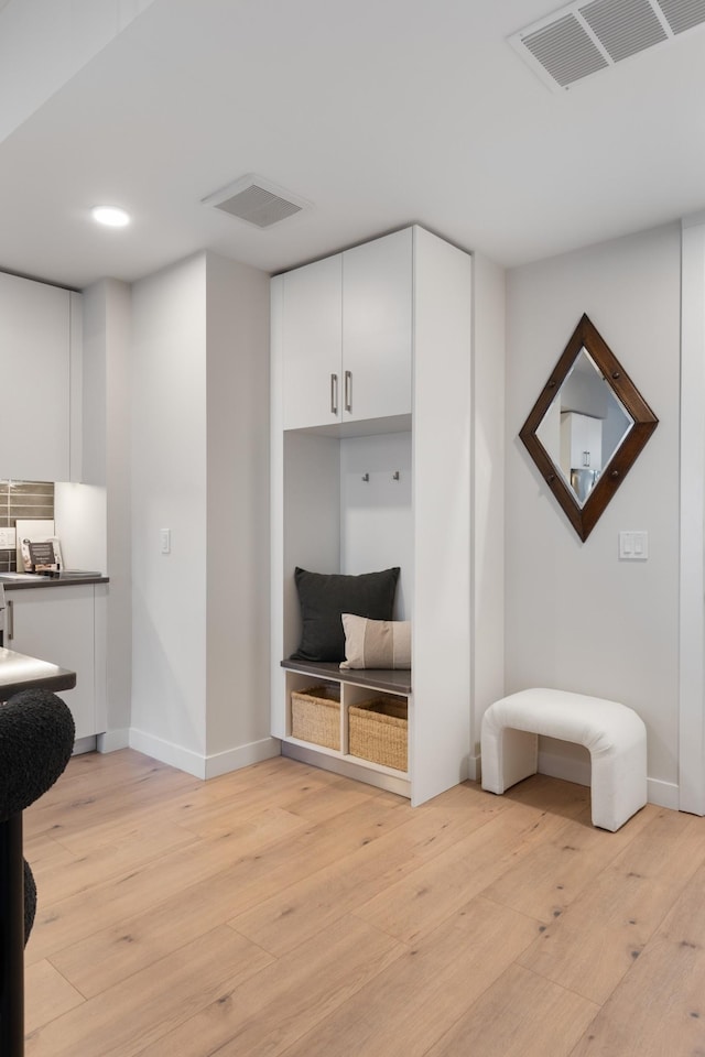 mudroom with visible vents, baseboards, and light wood-style floors