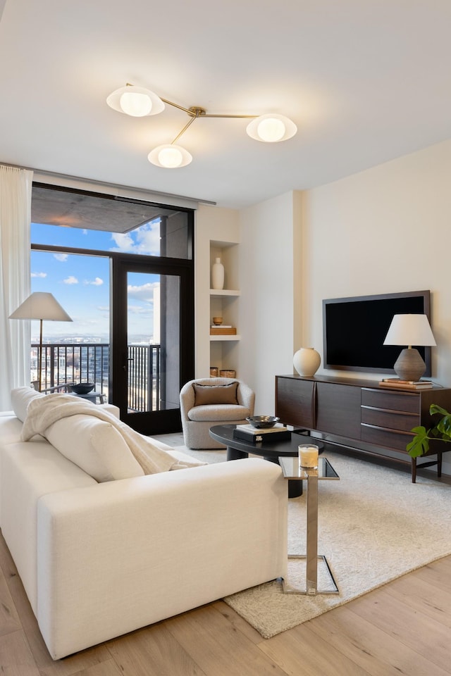 living area with built in shelves and wood finished floors