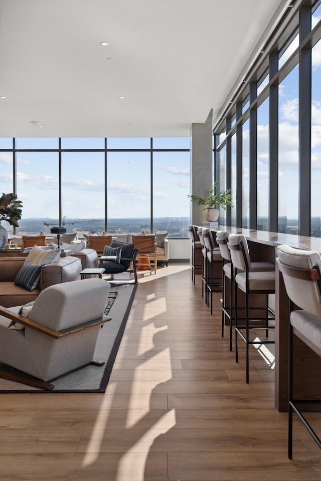 living room featuring a wall of windows and wood finished floors