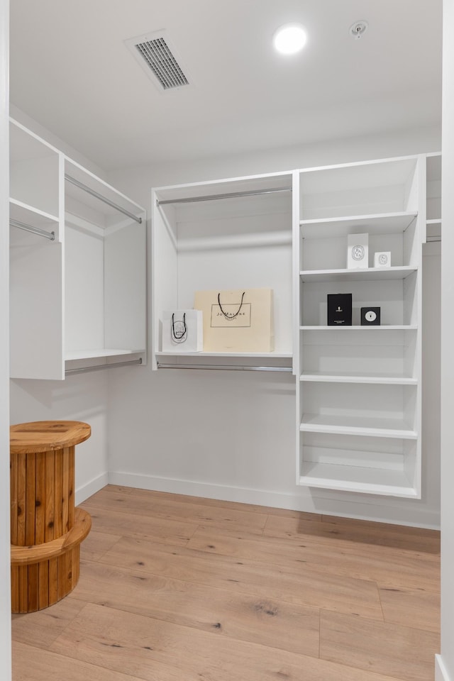 walk in closet with wood finished floors and visible vents