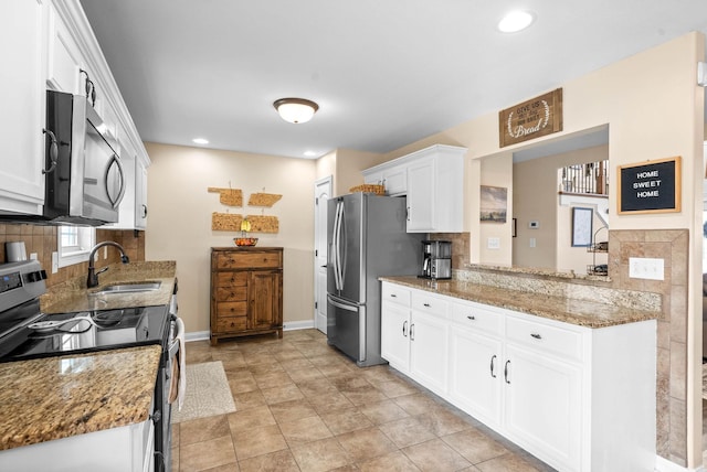 kitchen with white cabinets, a sink, stainless steel appliances, backsplash, and recessed lighting