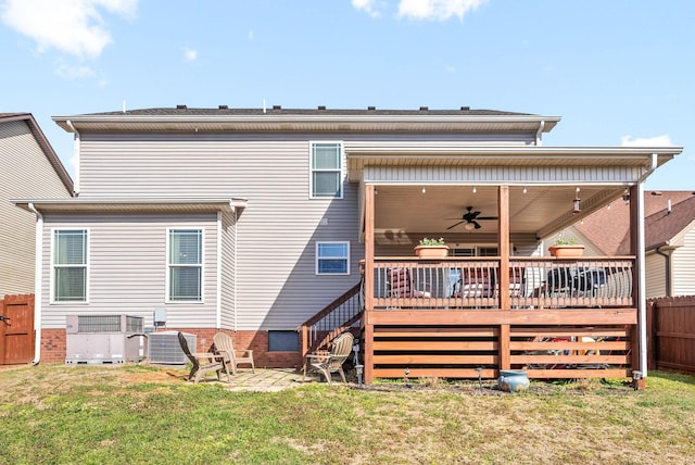 rear view of property featuring central AC, fence, a yard, a wooden deck, and a patio area