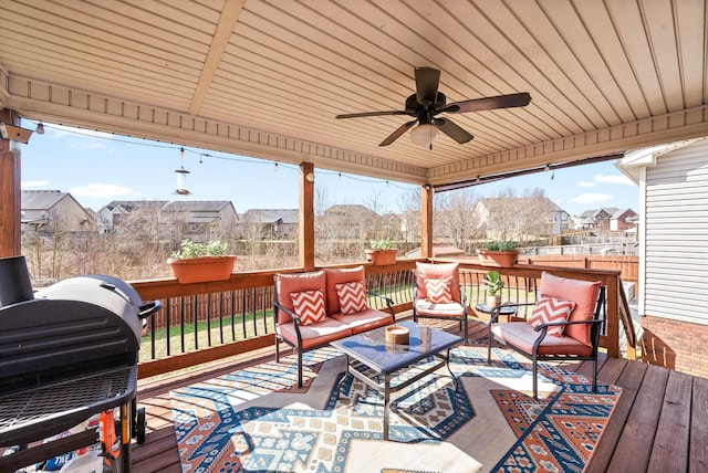 wooden terrace featuring fence, an outdoor living space, a ceiling fan, grilling area, and a residential view