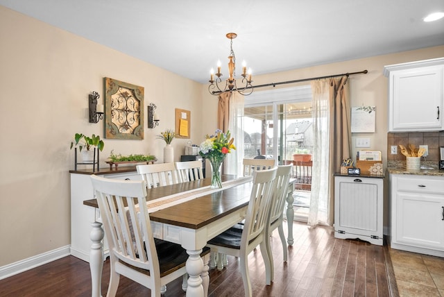 dining room with baseboards, wood finished floors, and a notable chandelier