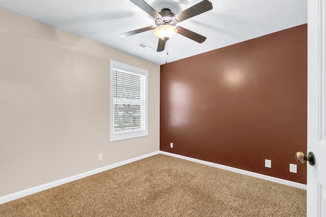 unfurnished room featuring ceiling fan, a textured ceiling, visible vents, baseboards, and carpet