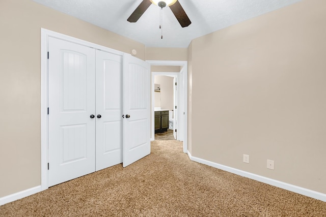 unfurnished bedroom featuring light carpet, baseboards, and a closet