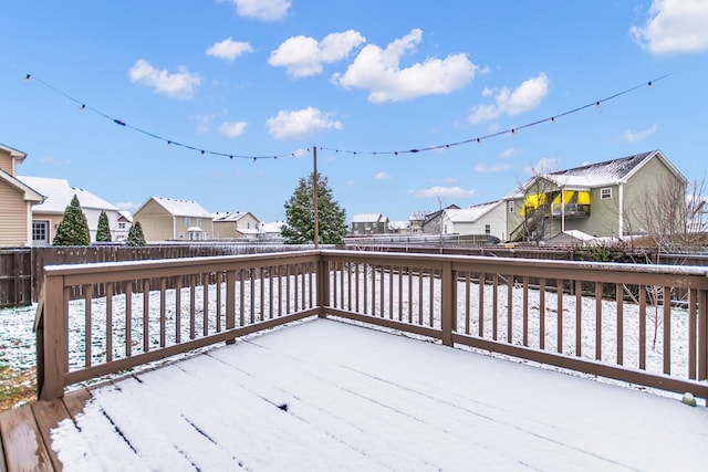 snow covered deck with a patio area, a fenced backyard, and a residential view