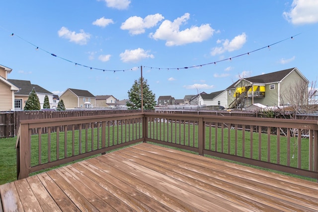 deck with a fenced backyard, a residential view, and a lawn