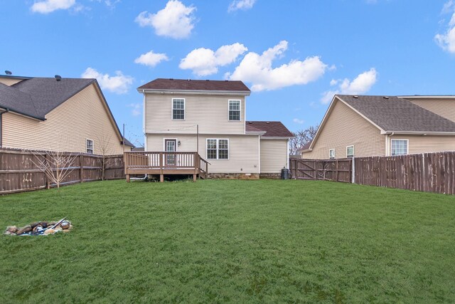 rear view of property with a lawn, a fenced backyard, and a wooden deck