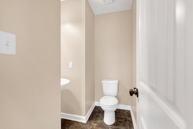 bathroom featuring toilet, baseboards, and tile patterned floors