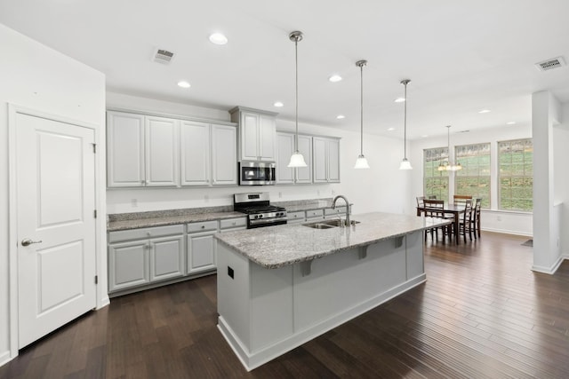 kitchen featuring dark wood-style floors, visible vents, stainless steel appliances, and a sink