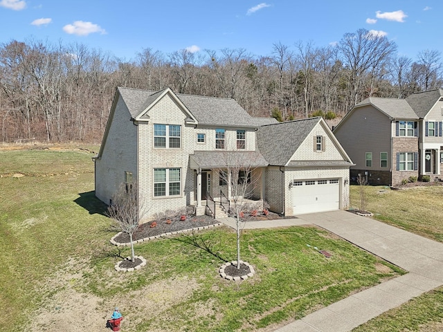 traditional-style home featuring driveway, a shingled roof, an attached garage, a front lawn, and brick siding