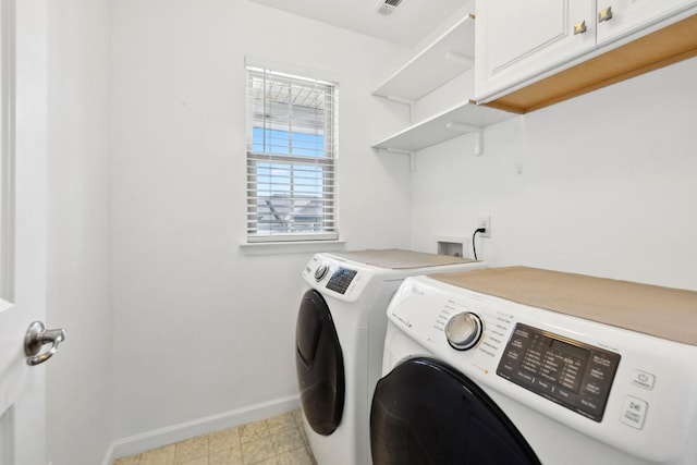 clothes washing area with visible vents, washing machine and clothes dryer, cabinet space, and baseboards