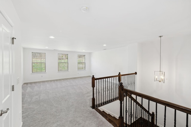 hall with recessed lighting, an inviting chandelier, carpet flooring, an upstairs landing, and baseboards