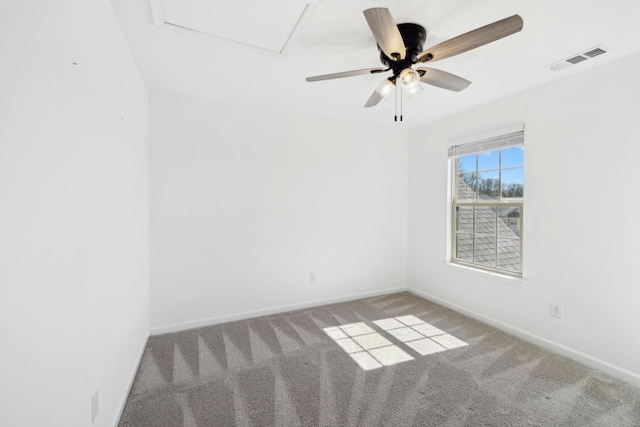 carpeted spare room featuring visible vents, ceiling fan, and baseboards