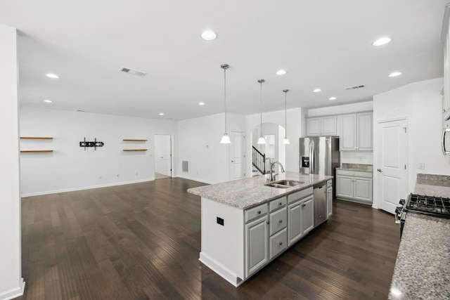 kitchen featuring visible vents, arched walkways, open floor plan, dark wood-style flooring, and a sink