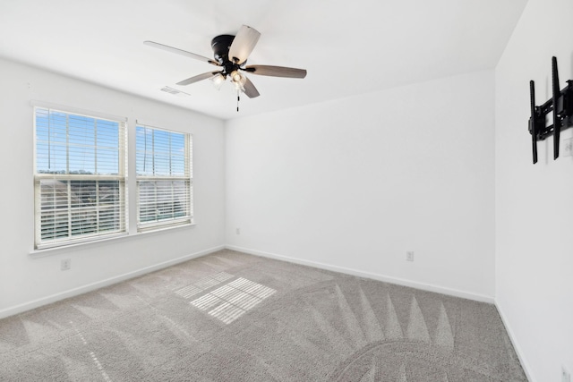 spare room featuring carpet, visible vents, and baseboards