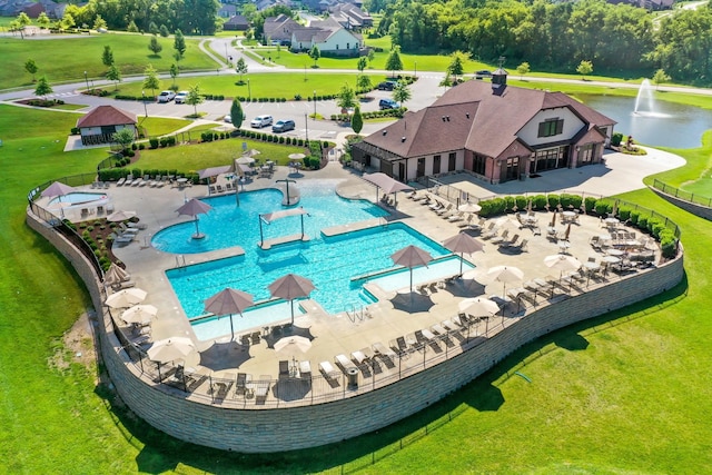 view of pool with a patio area, a water view, and fence