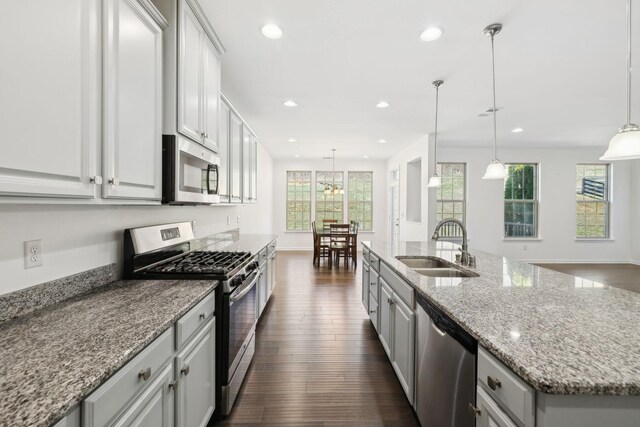 kitchen with a sink, appliances with stainless steel finishes, dark wood-type flooring, and recessed lighting