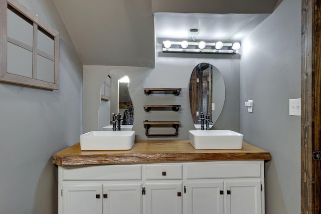 full bathroom featuring a sink and double vanity