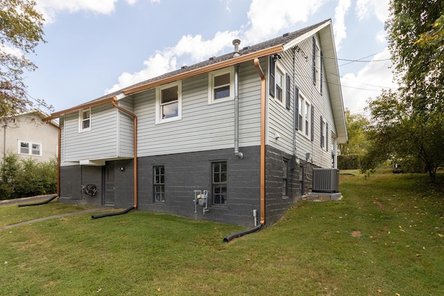 back of house featuring cooling unit and a lawn