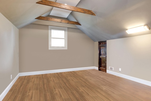 additional living space featuring vaulted ceiling, baseboards, and wood finished floors