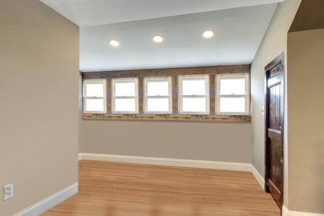 empty room with recessed lighting, light wood-type flooring, and baseboards