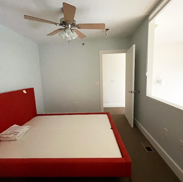 unfurnished bedroom with a ceiling fan, visible vents, and baseboards