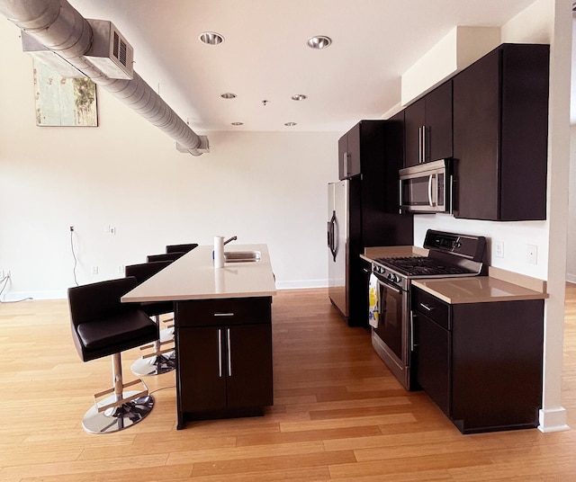 kitchen featuring a sink, light countertops, light wood-style flooring, and stainless steel appliances