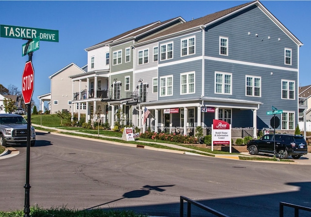 exterior space featuring sidewalks, traffic signs, a residential view, and curbs