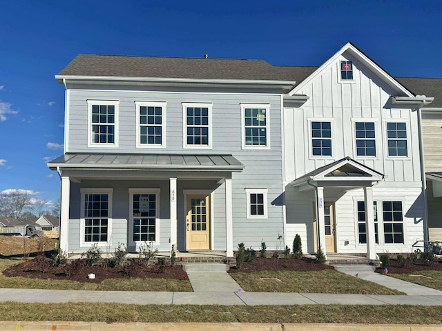 view of front of home with a shingled roof, covered porch, board and batten siding, a standing seam roof, and metal roof