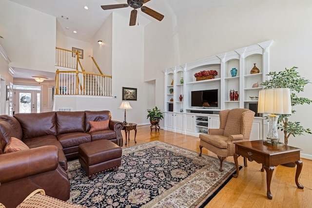 living area featuring a high ceiling, wood finished floors, a ceiling fan, and recessed lighting