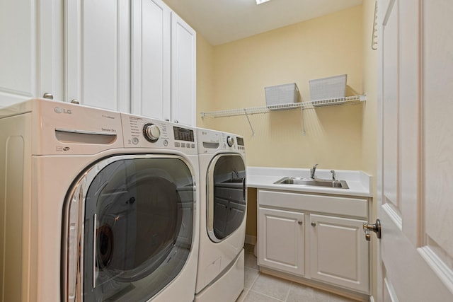 laundry area with a sink, light tile patterned flooring, washing machine and clothes dryer, and cabinet space