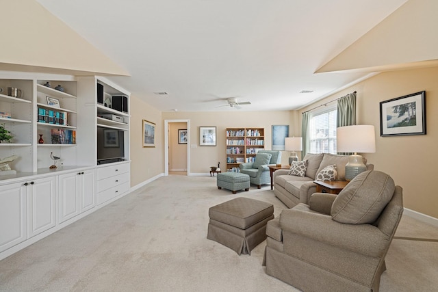 living room featuring built in shelves, light carpet, ceiling fan, and baseboards