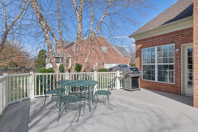 wooden terrace featuring outdoor dining area and grilling area