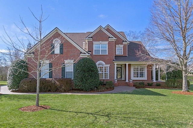 traditional home with brick siding and a front lawn