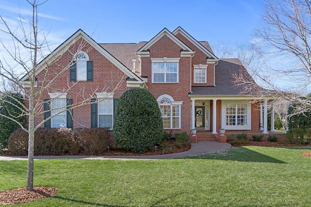 traditional-style house with a front yard and brick siding