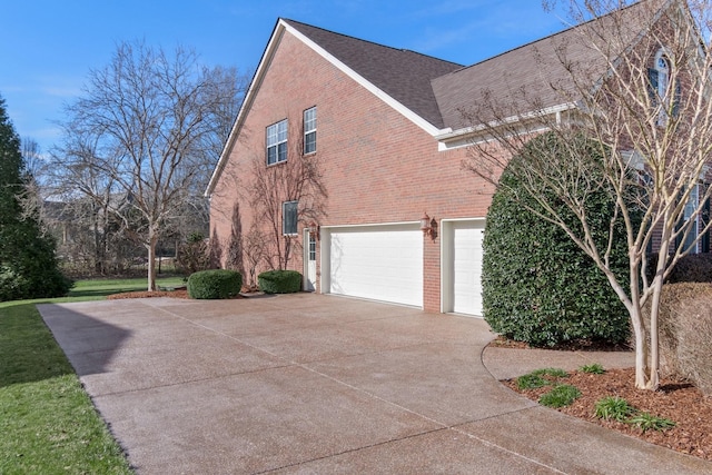 view of property exterior featuring an attached garage, roof with shingles, concrete driveway, and brick siding