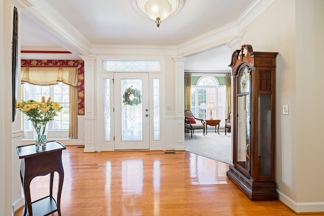 foyer entrance with wainscoting, decorative columns, and light wood-style floors