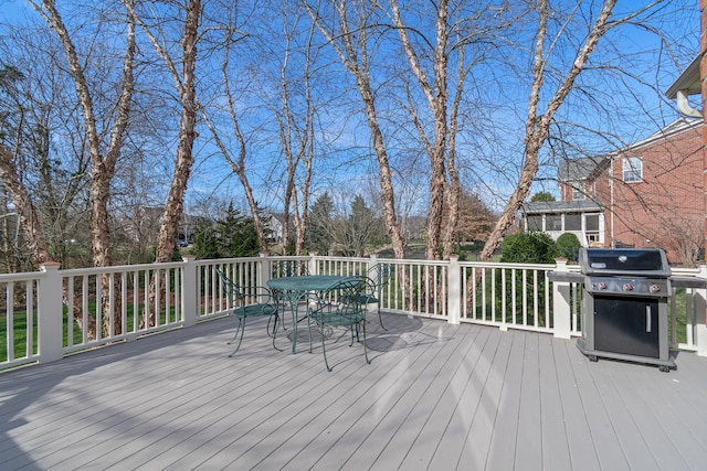 wooden terrace featuring outdoor dining space and a grill