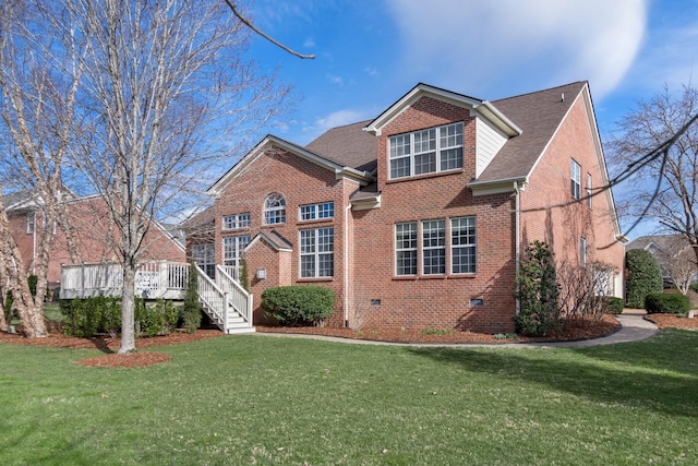 traditional-style house with crawl space, roof with shingles, a front yard, and brick siding