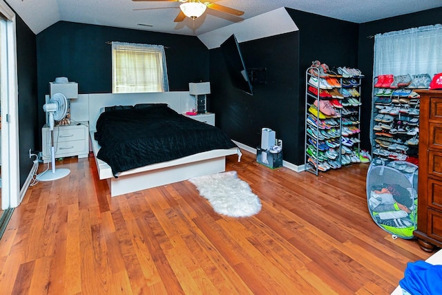 bedroom featuring lofted ceiling, ceiling fan, wood finished floors, and visible vents