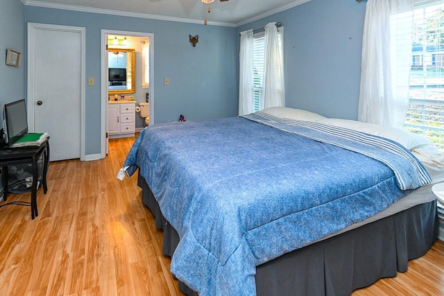 bedroom with ornamental molding, multiple windows, ensuite bath, and light wood finished floors