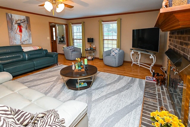 living room with ornamental molding, wood finished floors, and a ceiling fan